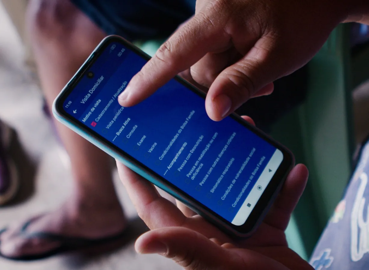 Profissional usando o celular para registrar atendimento
