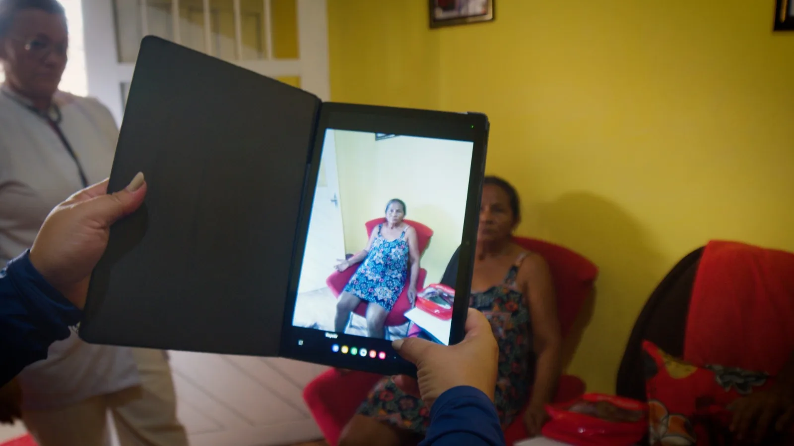 Profissional registrando atendimento em um tablet durante visita